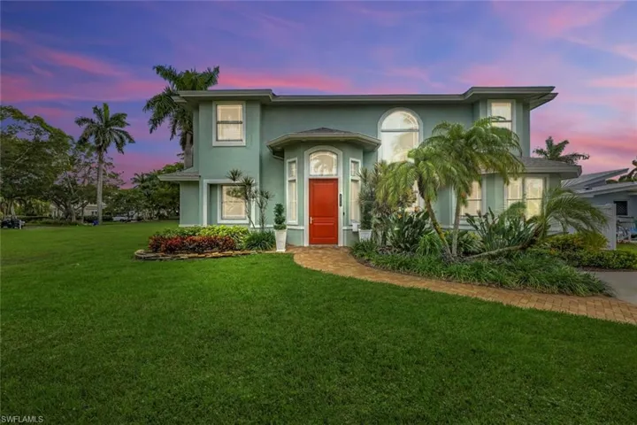 View of front of house with a front lawn and stucco siding