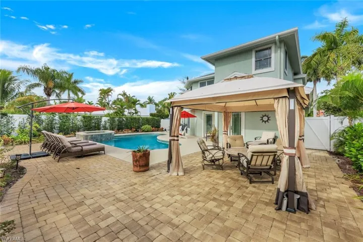 View of swimming pool with an outdoor living space, a gazebo, a patio area, a fenced backyard, and a pool with connected hot tub