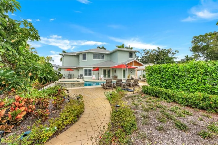 Back of property featuring a patio, a pool with connected hot tub, and stucco siding