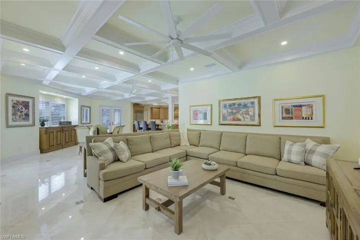 Living area with coffered ceiling, beam ceiling, ceiling fan, and recessed lighting