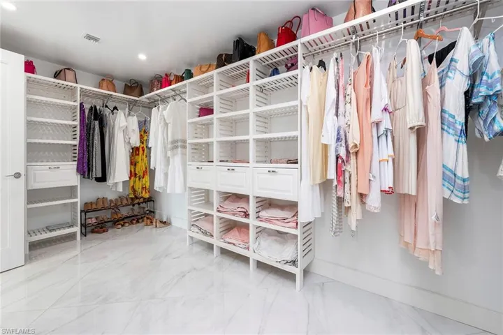 Walk in closet with light marble finish flooring