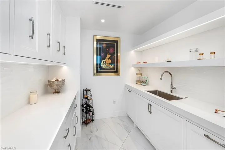 Bar area featuring tasteful backsplash, white cabinets, open shelves, recessed lighting, and light stone counters