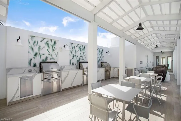 View of rooftop patio / terrace with area for grilling, and outdoor dining space.