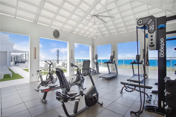 Rooftop Exercise room featuring a water view, high vaulted ceiling, and ceiling fan