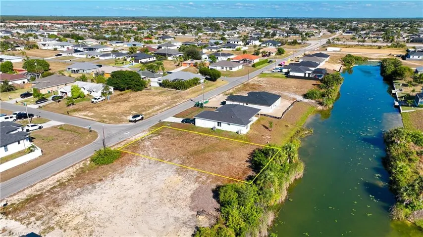 Aerial perspective of suburban area with property boundaries highlighted and a large body of water