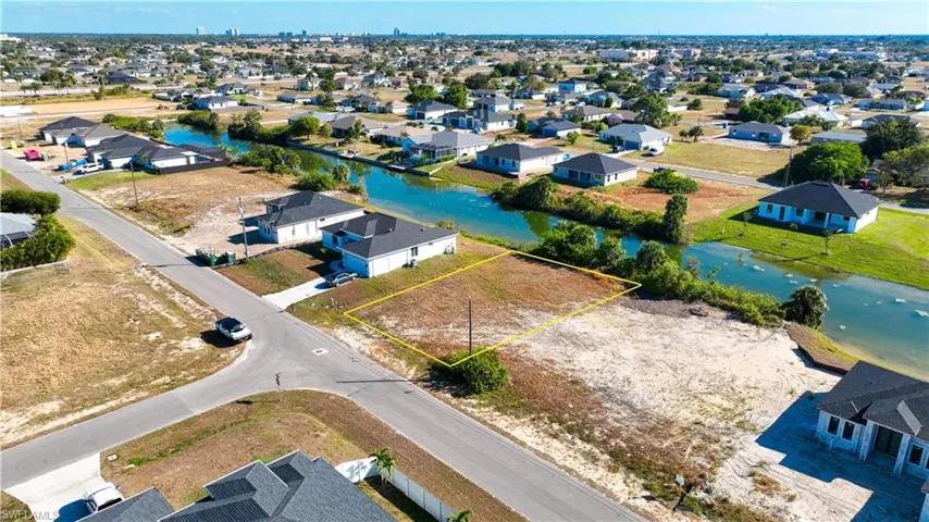 Aerial perspective of suburban area with property parcel outlined and a large body of water