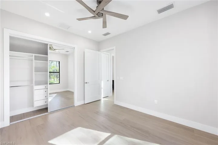 Unfurnished bedroom featuring ceiling fan, light wood-type flooring, and a closet