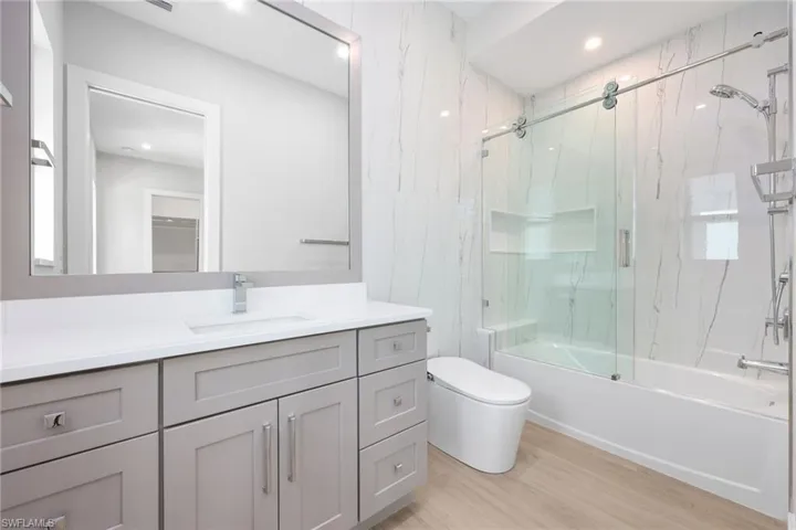 Guest room with bathtub and smart toilet, porcelain tile and quartz