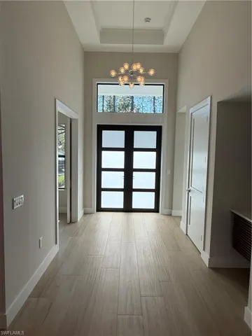 Foyer entrance with a tray ceiling, a towering ceiling and an inviting chandelier