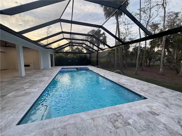 View of swimming pool featuring a lanai and a patio area