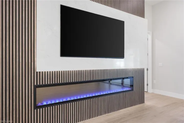 Custom built in entertainment center with fireplace and custom recessed lighting behind quartz