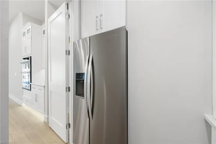Kitchen with oversized island with dual faucets, waterfall quartz tops, wireless charging, custom built in wood, high end light fixtures and JennAir appliances with Butler pantry%2