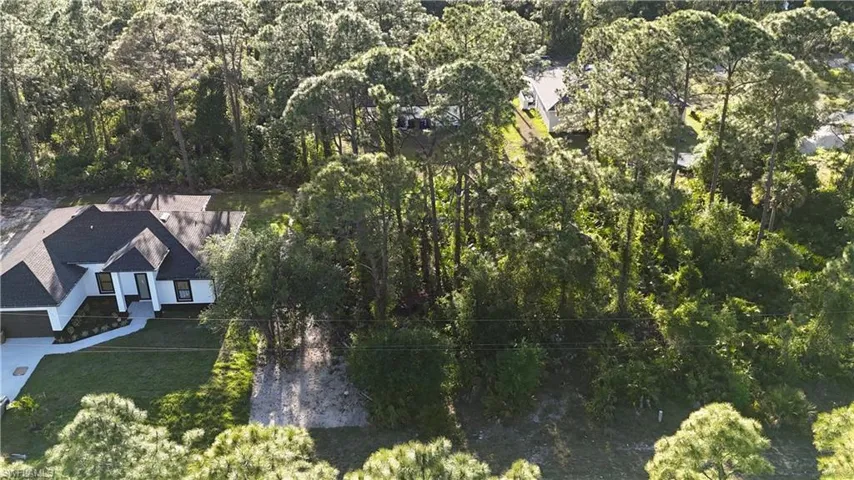 Birds eye view of property featuring a wooded view