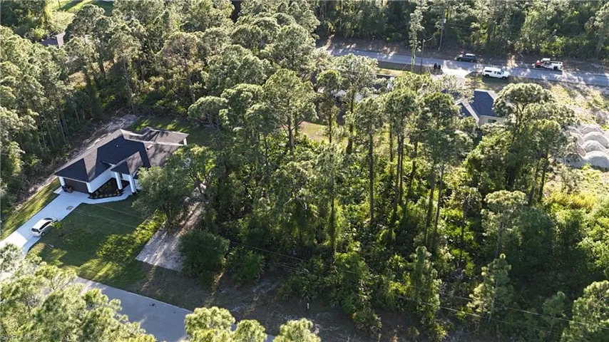 Birds eye view of property with a wooded view