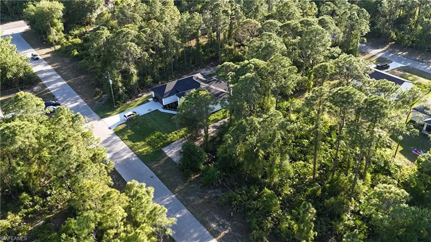 Birds eye view of property featuring a view of trees