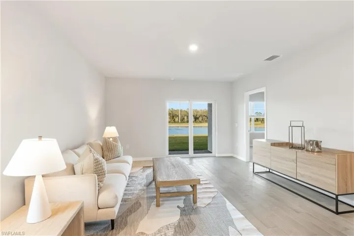 Living room featuring light wood finished floors, baseboards, and recessed lighting