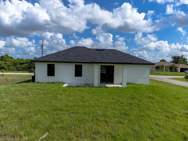 Rear view of property with a yard
