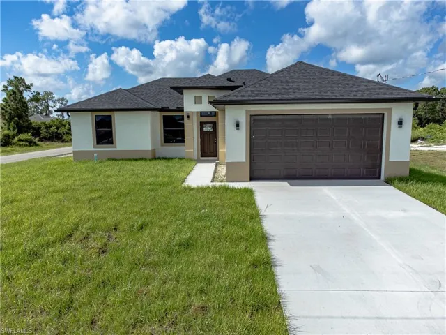 View of front of property featuring a garage and a front yard