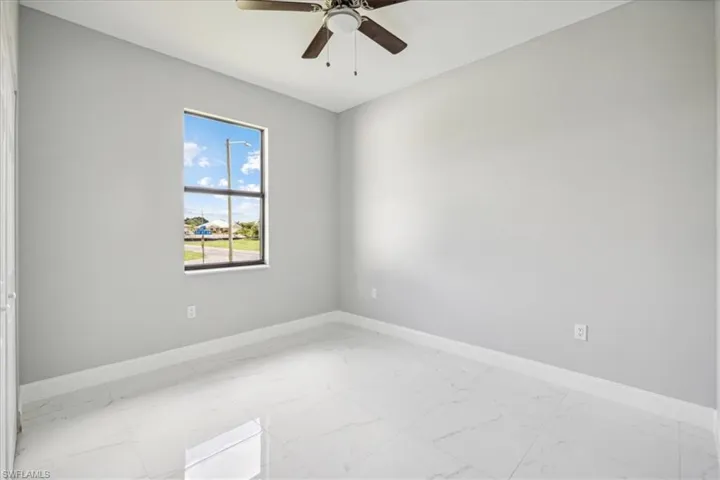 Tiled empty room with ceiling fan