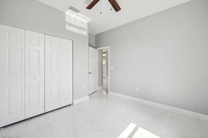 Unfurnished bedroom featuring a closet, ceiling fan, and light tile patterned floors