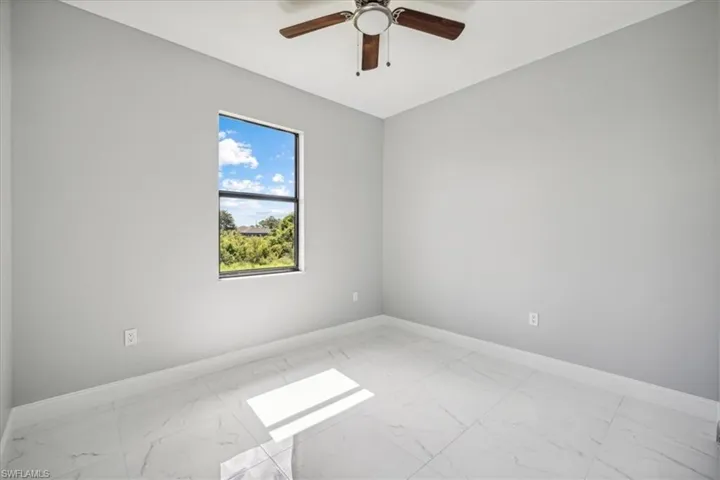 Spare room featuring light tile patterned floors and ceiling fan