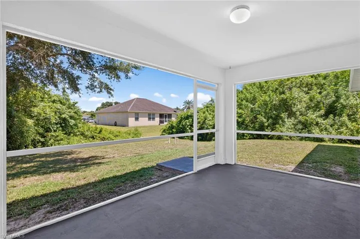 Screened patio featuring a solid ceiling, concrete flooring, and an exterior light fixture