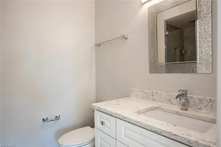 Bathroom with an enclosed shower, vanity, and toilet
