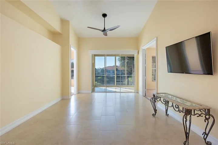 Unfurnished living room featuring ceiling fan and light tile patterned floors