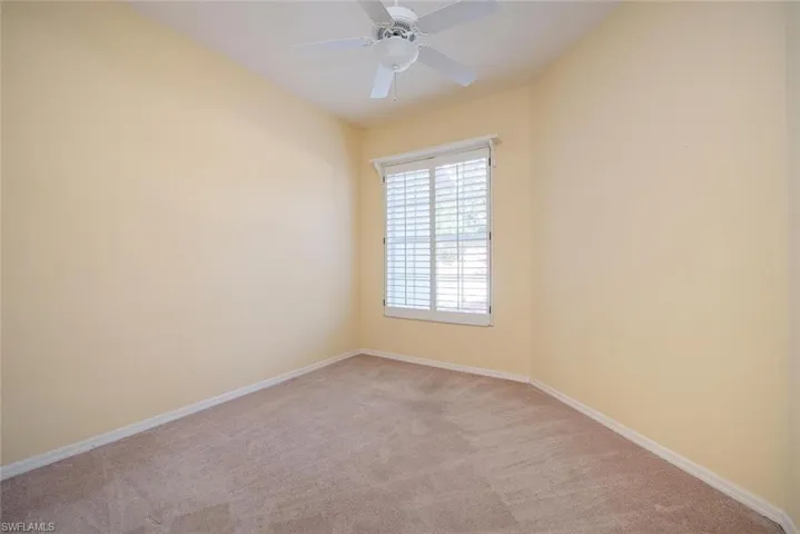 Spare room featuring light carpet and ceiling fan