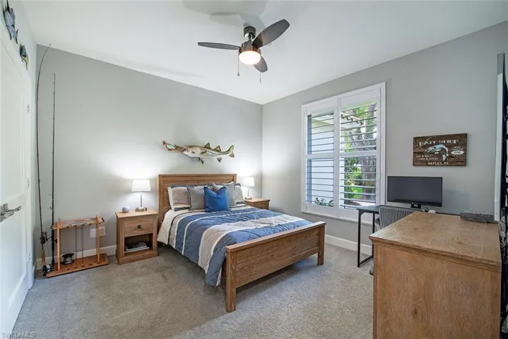 Carpeted bedroom featuring ceiling fan