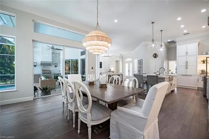 Dining room featuring dark hardwood / wood-style floors with notable chandelier, and ornamental molding