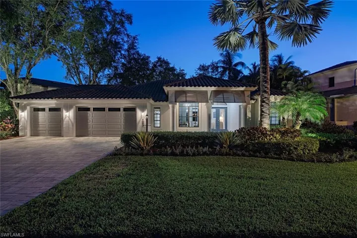 Mediterranean / spanish home with a garage and a front lawn