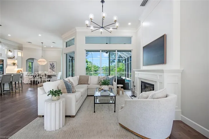 Living room featuring ornamental molding, wood-type flooring, and a chandelier