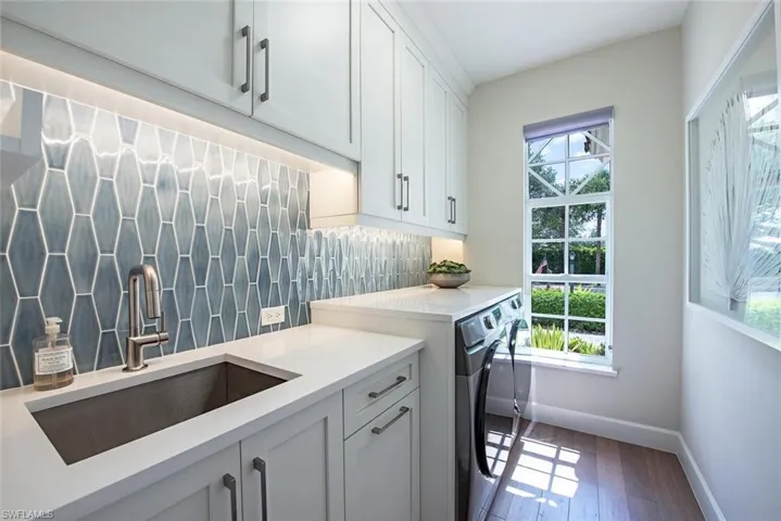 Washroom featuring sink, cabinets, a wealth of natural light, and hardwood / wood-style floors