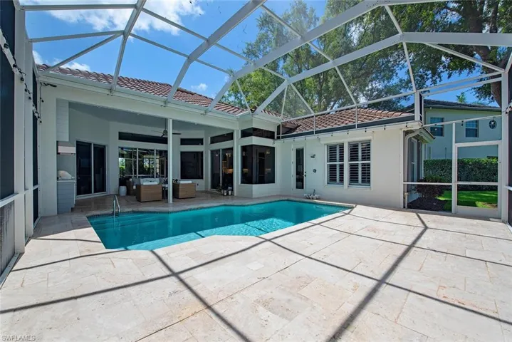 View of pool featuring ceiling fan, a patio area, and a screened lanai.