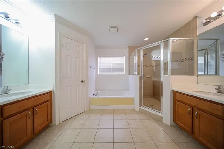 Bathroom with tile floors, separate shower and tub, and vanity
