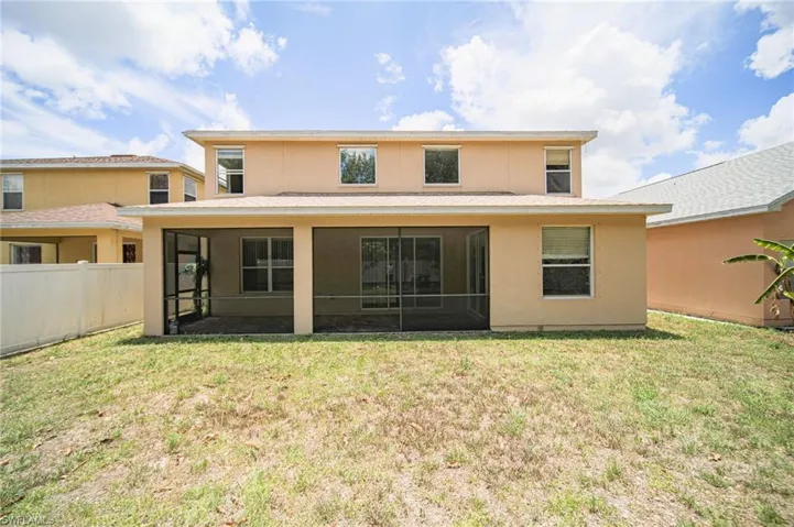 Back of house featuring a sunroom and a lawn
