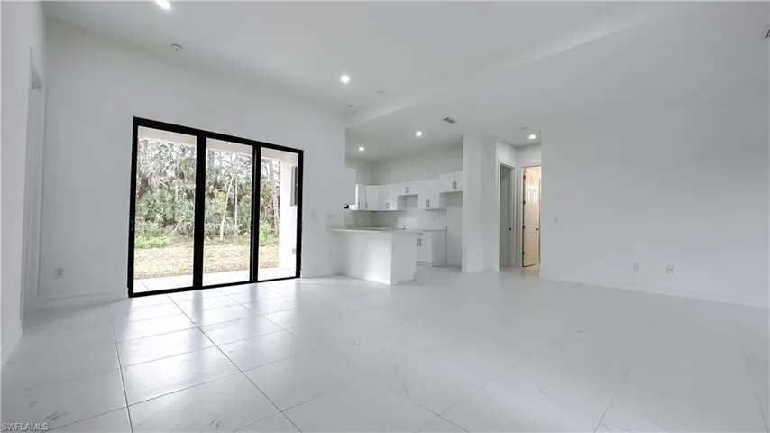 Unfurnished living room with recessed lighting and baseboards