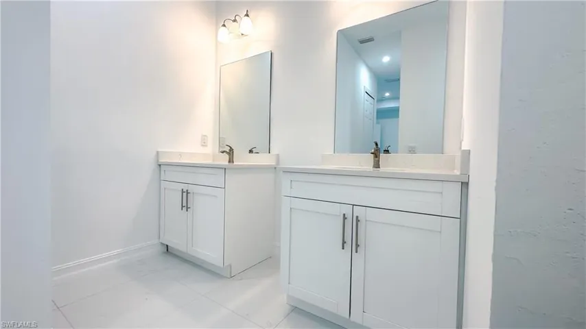 Bathroom with two vanities and marble finish floors