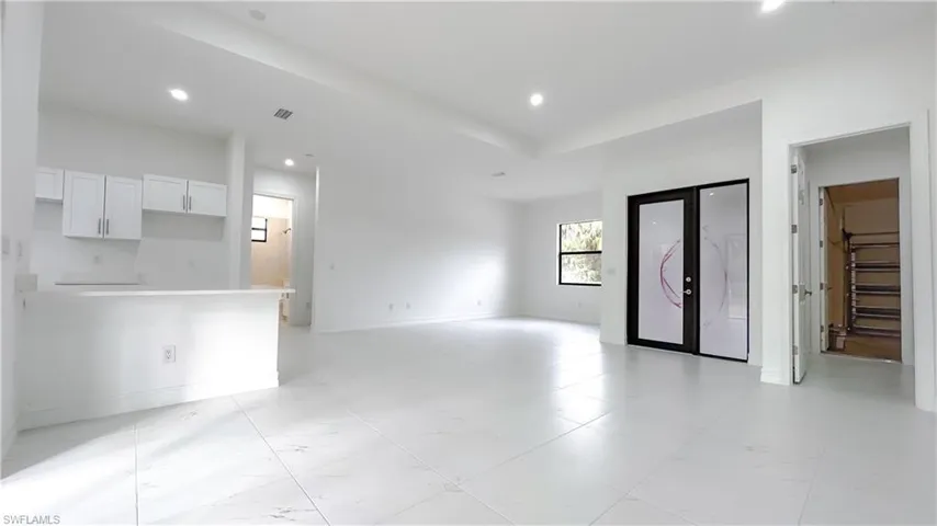 Unfurnished living room with recessed lighting and baseboards