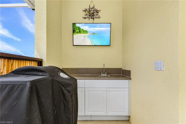 Laundry area featuring a textured wall and a sink