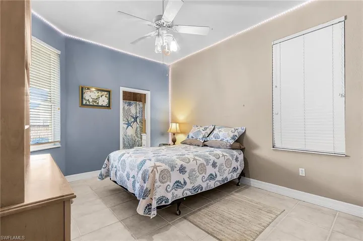 Bedroom with ceiling fan and light tile patterned flooring