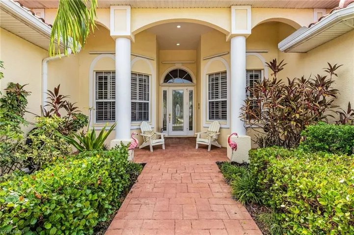 Property entrance with stucco siding, a porch, and french doors