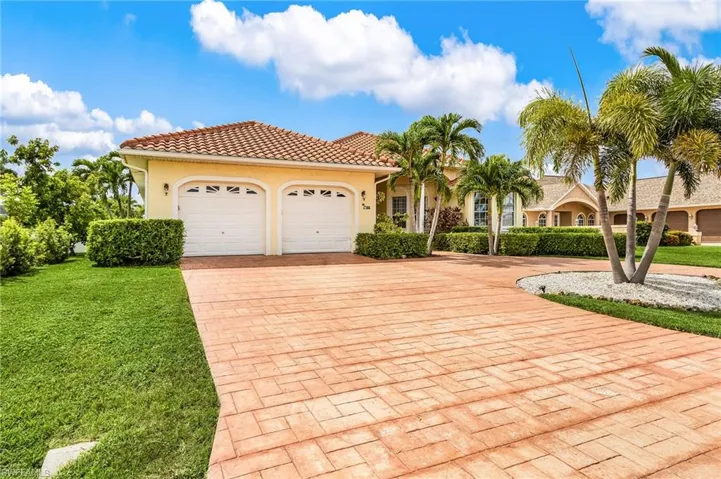 Mediterranean / spanish home with decorative driveway, stucco siding, a tile roof, a garage, and a front yard