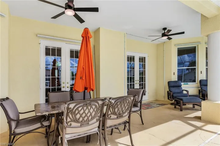 View of patio featuring french doors, outdoor dining area, and ceiling fan