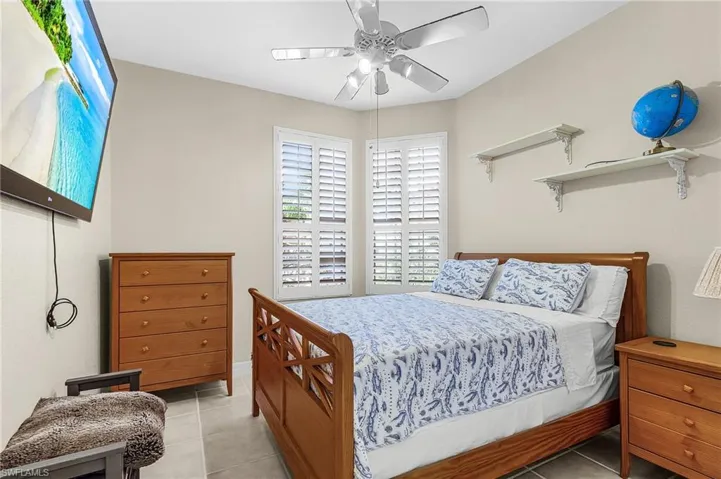 Bedroom featuring light tile patterned floors and ceiling fan