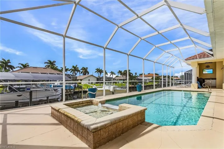 Outdoor pool featuring a sunroom, a residential view, a patio area, and glass enclosure