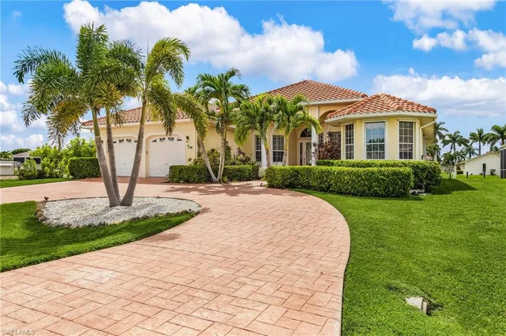 Mediterranean / spanish-style home with decorative driveway, a tiled roof, a front lawn, and stucco siding