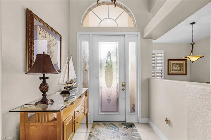 Entryway featuring light tile patterned flooring and a textured wall