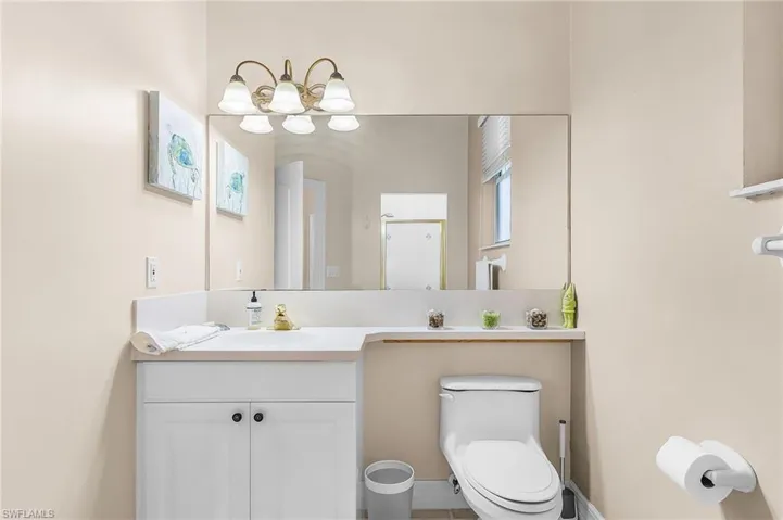 Bathroom with vanity, a chandelier, and a shower stall